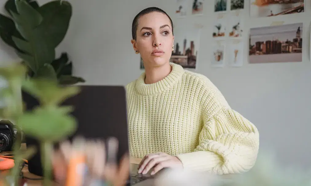 A jobseeker pausing thoughtfully at their laptop